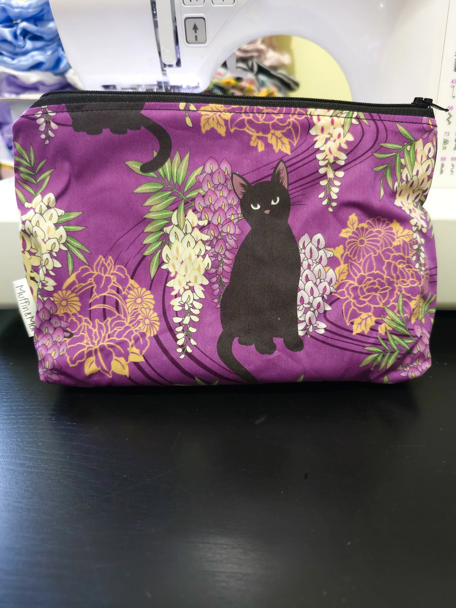 Black cat pouch with purple background