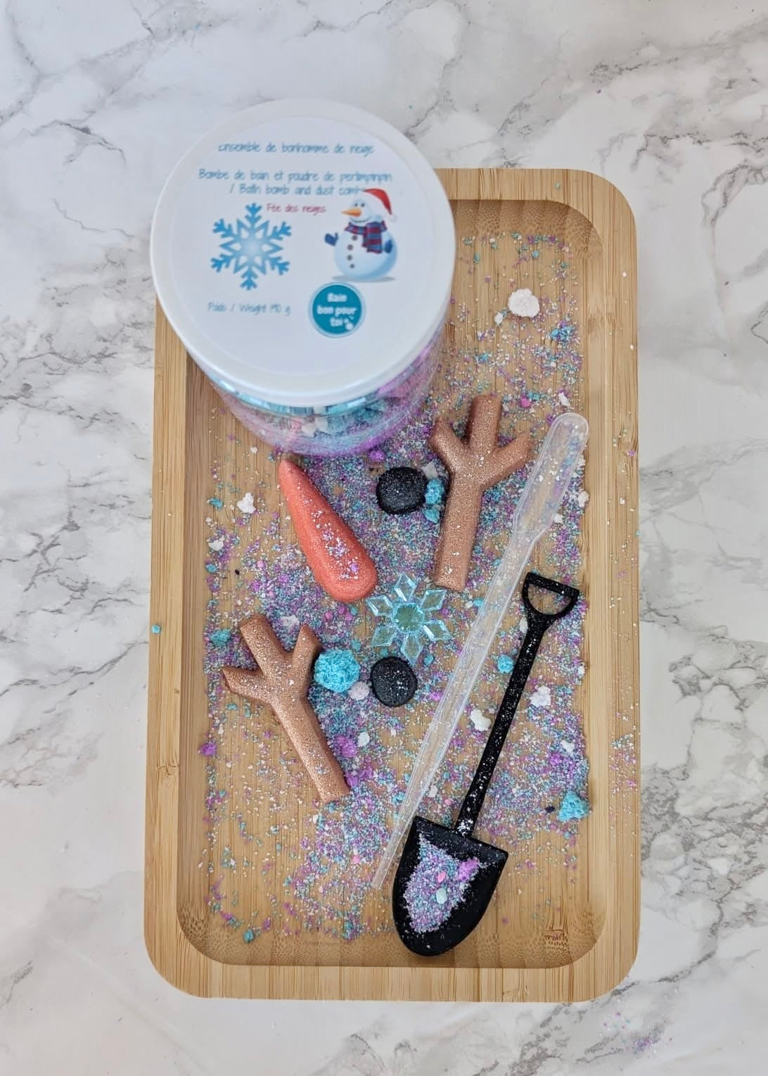 Pot avec poudre de bain et morceaux de bonhomme de neige avec pipette et pelle